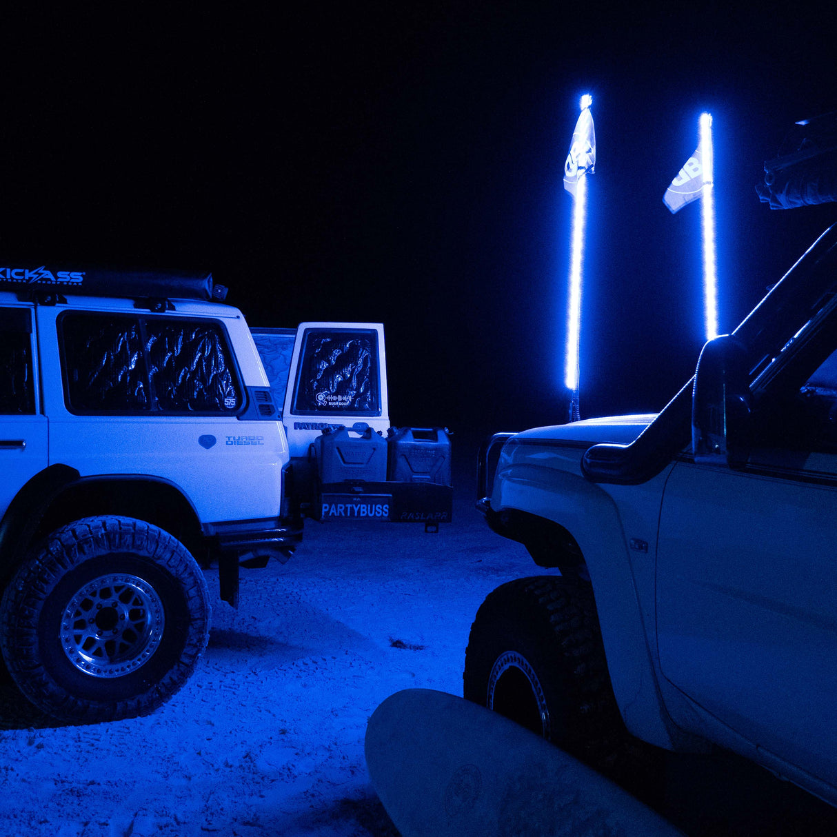 Off-road vehicles with rugged tires and blue LED light whips at night, LynXautoinnovate USA automotive accessories