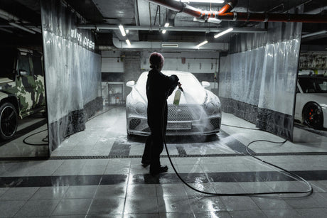 Person detailing luxury car with foam spray in modern garage, LynXautoinnovate automotive parts