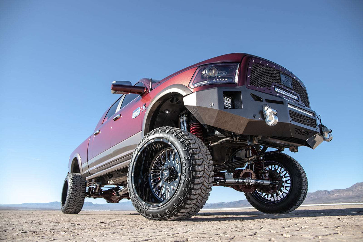 Lifted red truck with custom wheels, off-road bumper, and suspension in desert, LynXautoinnovate USA automotive parts