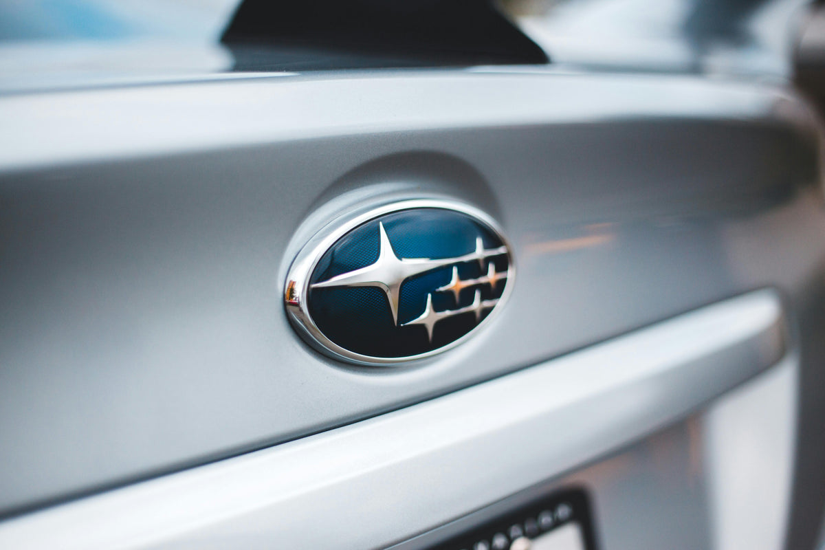 Close-up Subaru car emblem on silver vehicle trunk, LynXautoinnovate auto parts USA