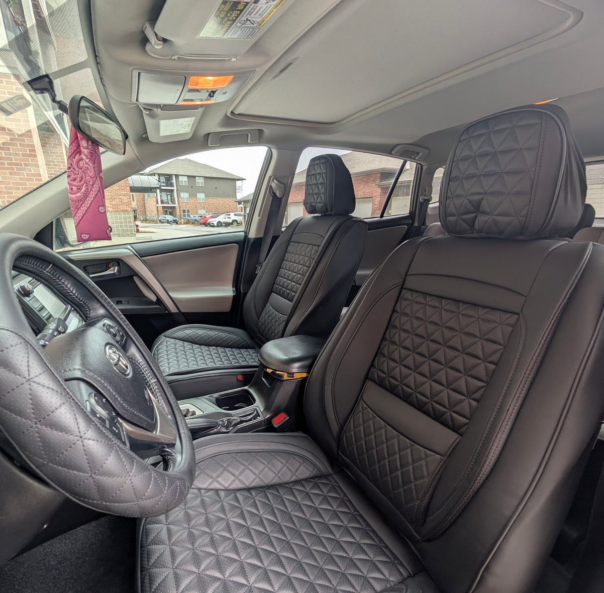 Car interior with quilted gray seats and dashboard.