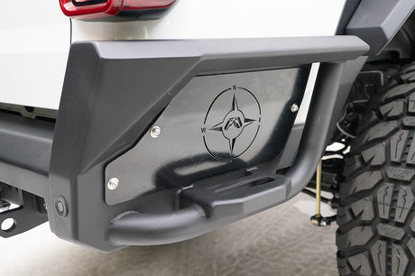 Close-up of a vehicle's rear bumper with a brand logo on a light background