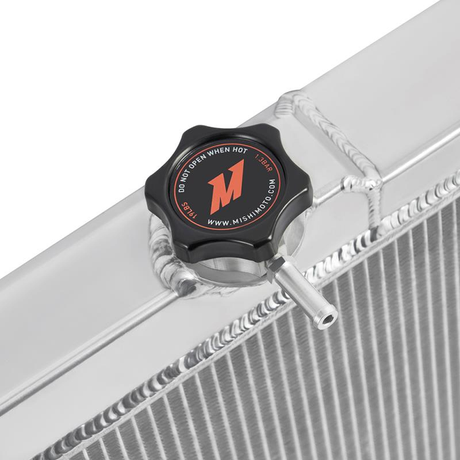 Radiator cap with Mishimoto logo on a radiator. The background is white