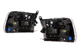 Two truck headlight assemblies viewing the back of the headlights. shows plug and play accessibility with a white background